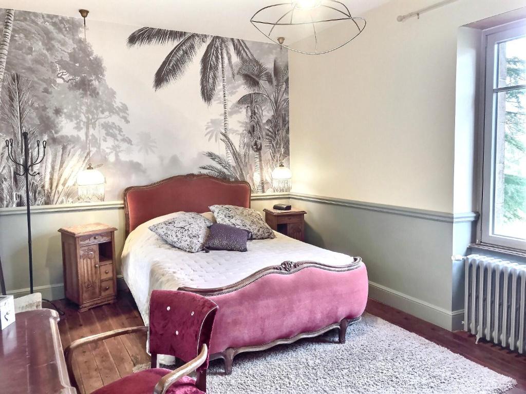 1 dormitorio con 1 cama rosa y un mural de palmeras en chambres d'hôtes maison de charme, en La Boissière-de-Montaigu