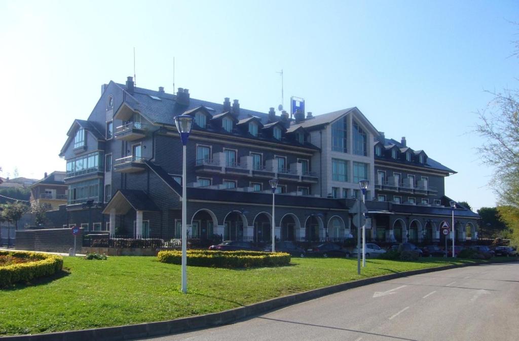 un gran edificio al lado de una calle en Hotel Milagros Golf, en Mogro