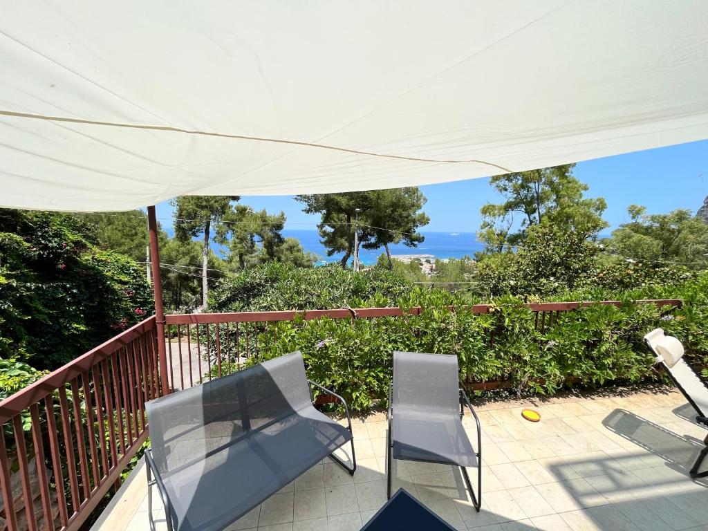 a patio with two chairs and a white umbrella at Porta Addaura in Palermo