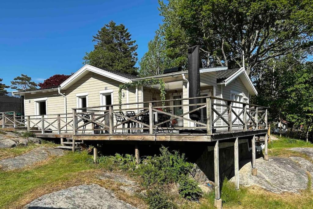 a white house with a wooden porch on a dock at Kullavik, 2 mil från Göteborg Villa Gläntan in Kullavik