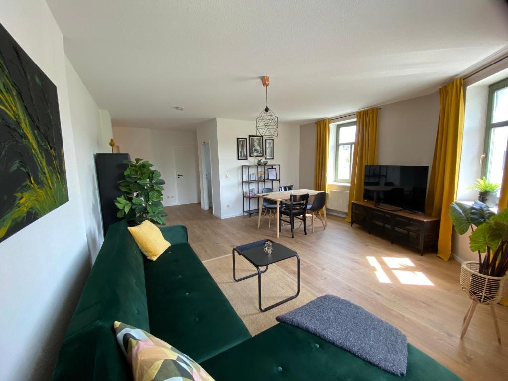 sala de estar con sofá verde y mesa en Midcentury-Smart-Home am Kaßberg, en Chemnitz