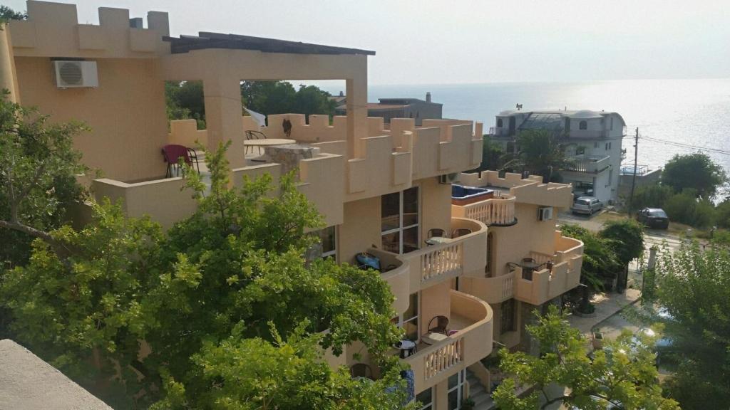 un immeuble d'appartements avec balcon et arbres dans l'établissement Violit Apartments&Restaurant, à Sutomore