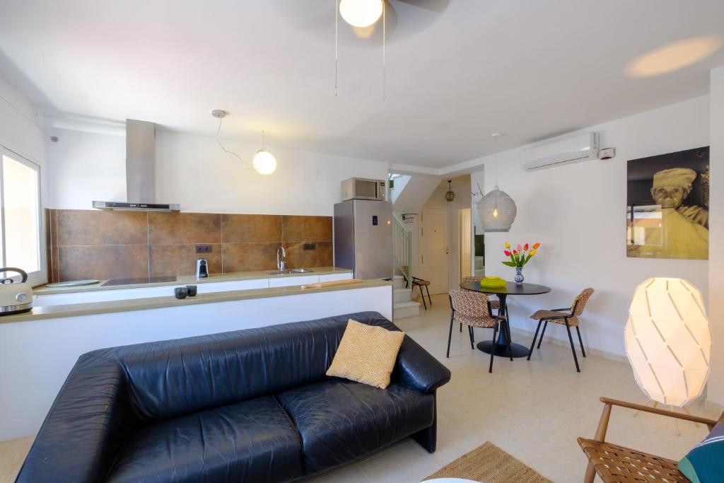 salon z czarną skórzaną kanapą i kuchnią w obiekcie LOFT2STAY.COM w Maladze