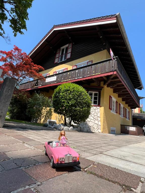 バートライヘンハルにあるLandhaus Luise fly in & sleepのピンクの玩具車に乗った少女
