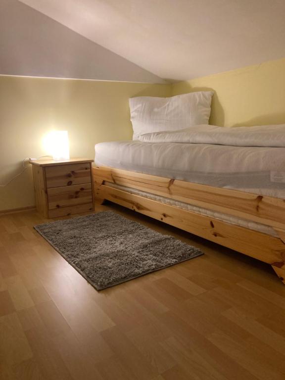 a bedroom with a bed with a wooden frame and a night stand at Familienchalets am Millstätter See in Rothenthurn