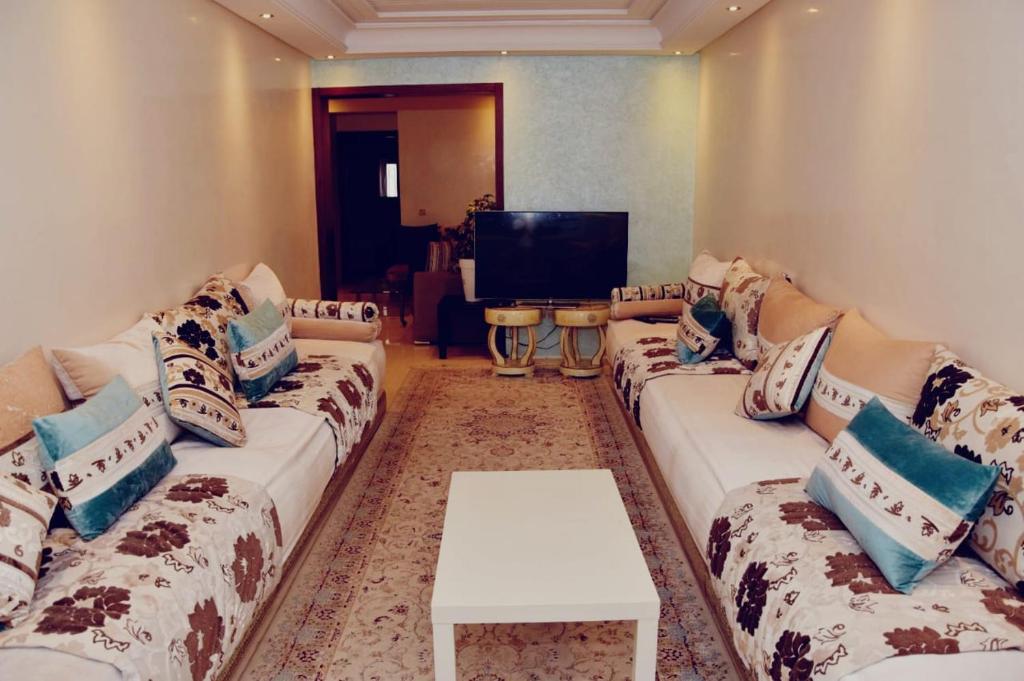sala de estar con sofá y TV en appartement rabat agdal, en Rabat