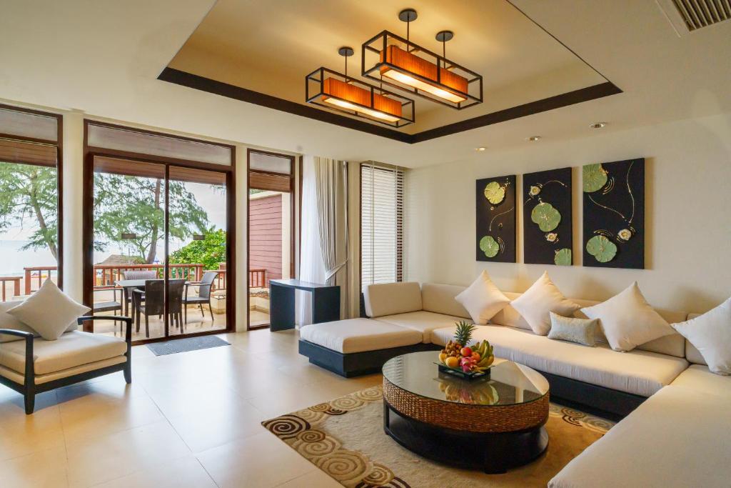a living room with a couch and a table at 2 Bedrooms Beachfront Pool Villas in Bang Tao Beach