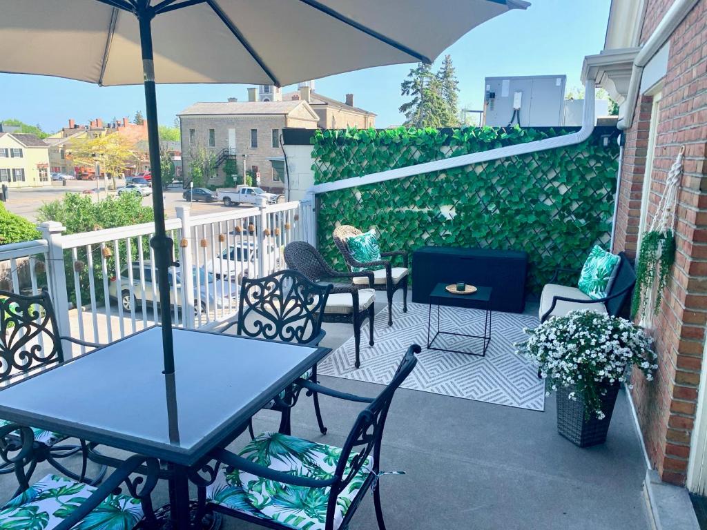 a patio with tables and chairs and an umbrella at Suites On King in Niagara on the Lake