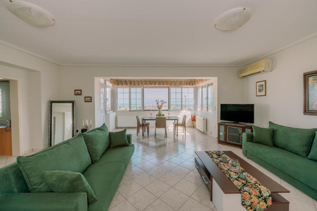 sala de estar con sofás verdes y mesa en AKANTHOS Rental House en Kórinthos