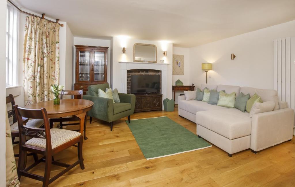 uma sala de estar com um sofá branco e uma mesa em The Garden Square - Unique luxury apartment in historic garden square - for up to 4 people em York