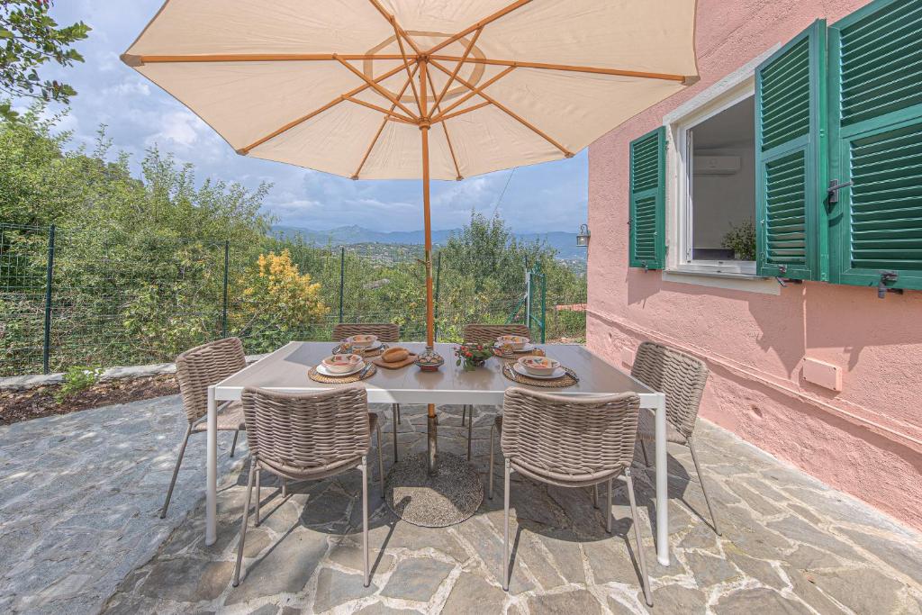 einen Tisch und Stühle mit Sonnenschirm auf einer Terrasse in der Unterkunft Casa Otti by PortofinoHomes in Santa Margherita Ligure