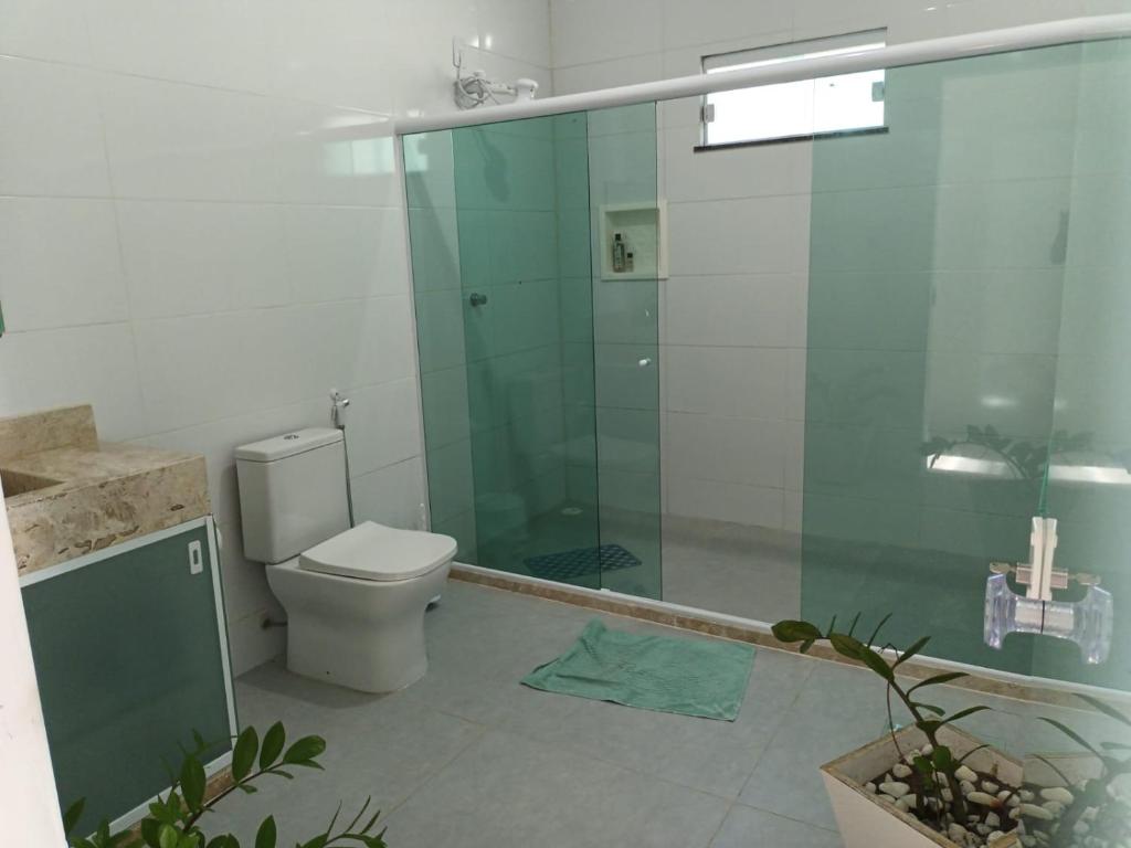 a bathroom with a toilet and a glass shower at Casa de praia em Barra do Gil in Vera Cruz de Itaparica