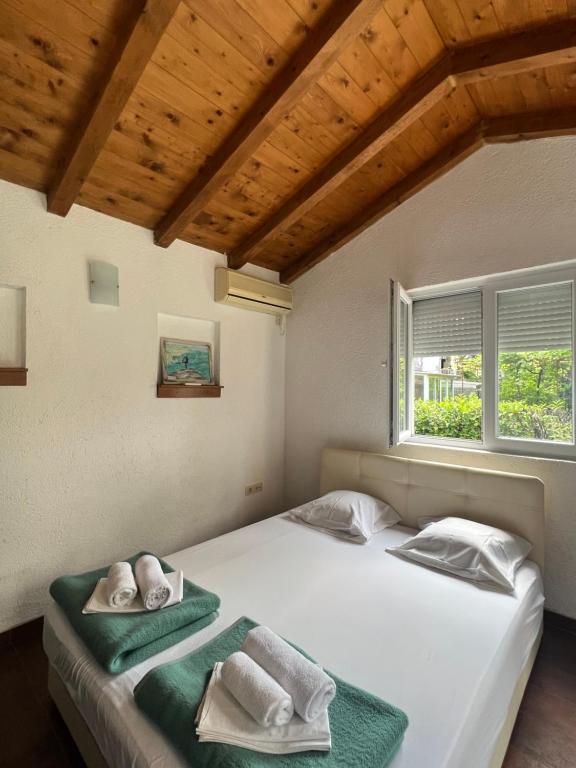 1 dormitorio con 2 camas y toallas. en Ksenia Guesthouse Apartments and Studios, en Budva