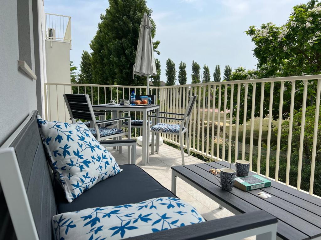a balcony with a table and chairs and an umbrella at Sogno di mare in Cavallino-Treporti