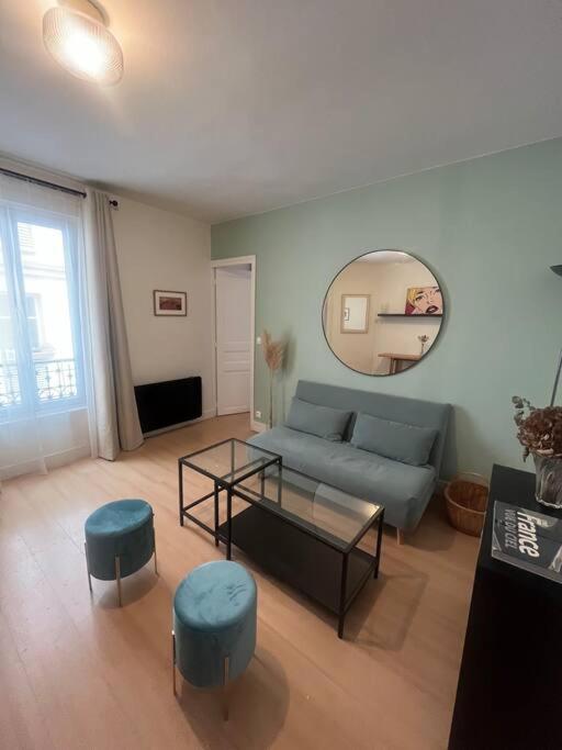 uma sala de estar com um sofá, uma mesa e cadeiras em Joli cocon proche de Paris centre em Boulogne-Billancourt