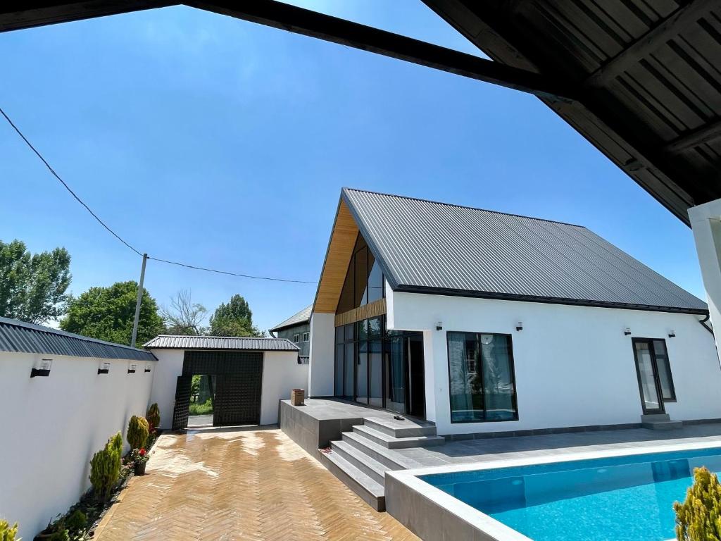 una casa blanca con piscina frente a ella en EMIREST Barnhouse en Gabala