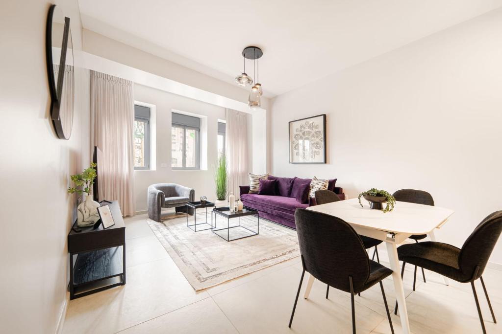a living room with a purple couch and a table at Agrippas St 8 - Isrentals in Jerusalem