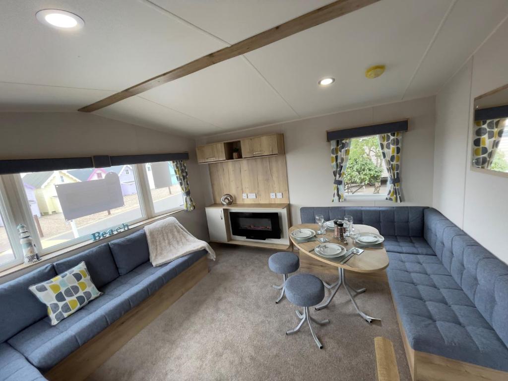 a living room with a blue couch and a table at Mersea Retreat in West Mersea