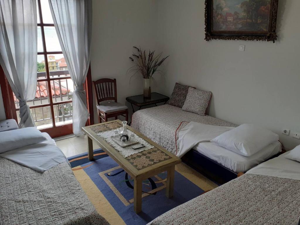 ein Wohnzimmer mit 2 Betten und einem Couchtisch in der Unterkunft Clock's House in Nafpaktos