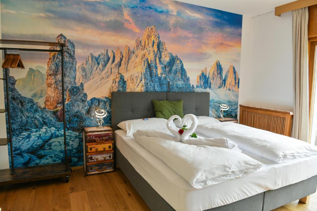 a bedroom with two beds with a mountain mural at Guesthouse Rosengarten in Dobbiaco