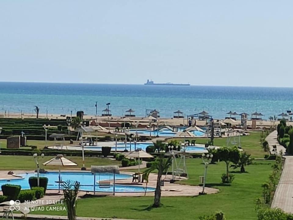 a resort with a pool and the ocean in the background at Chalet - Calipsio neighbourhood in Ras Sedr