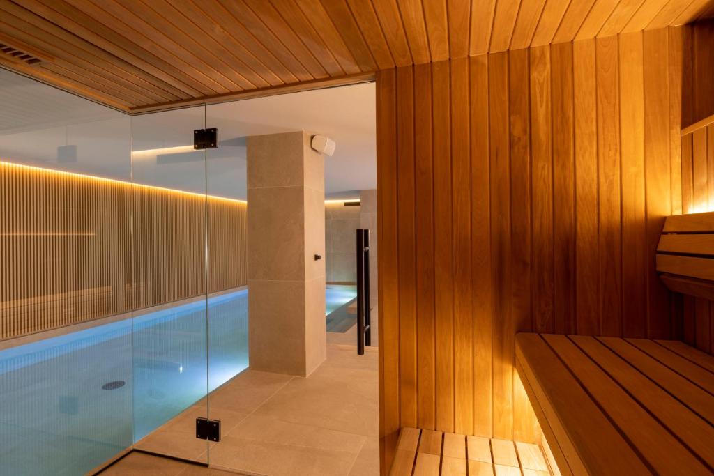 ein Raum mit Swimmingpool und Glaswand in der Unterkunft Hôtel Esté in Paris