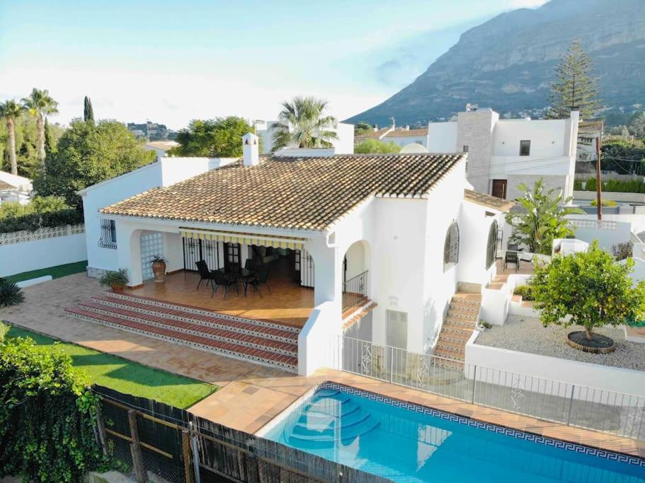 a white house with a swimming pool in front of it at Casa Anemone in Denia