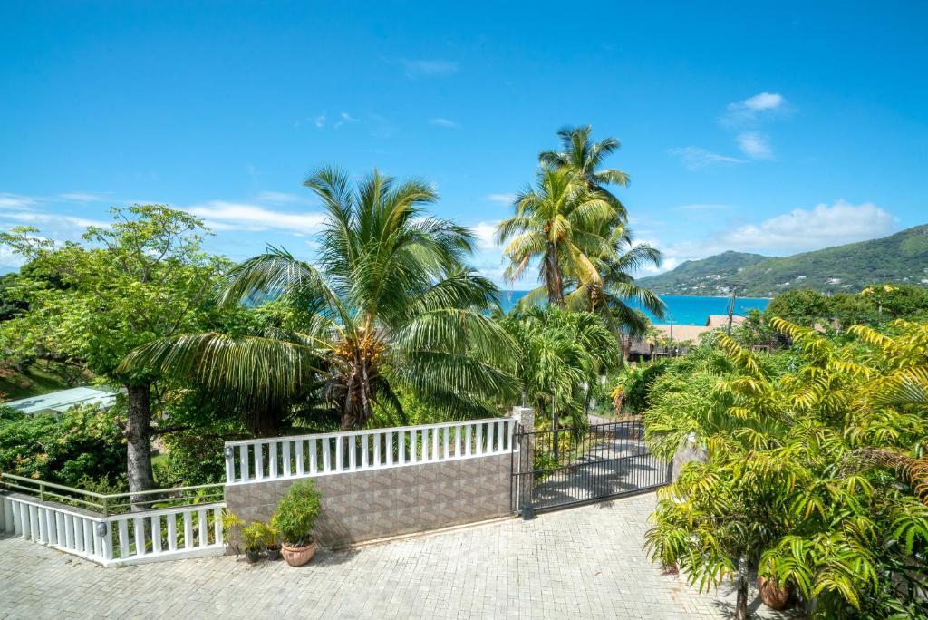 - une vue sur un complexe avec des palmiers et l'océan dans l'établissement La Belle Residence Self Catering Accommodation, à Beau Vallon