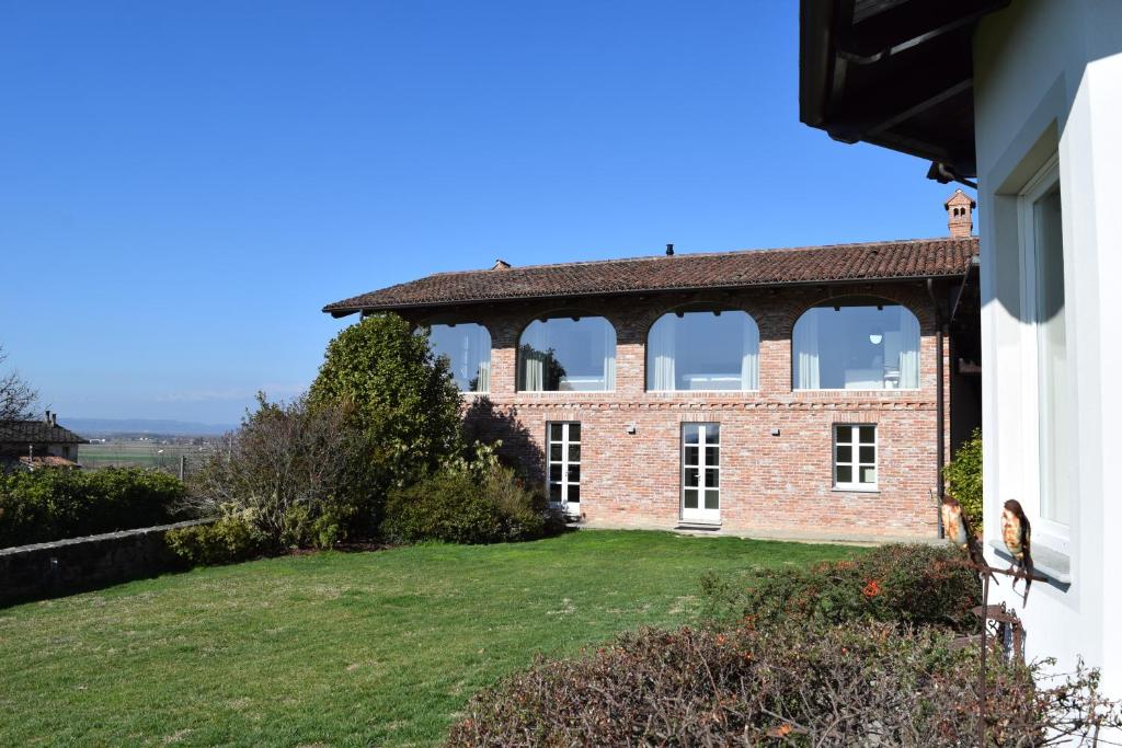 una vista exterior de una casa de ladrillo con grandes ventanas en MyVilla Suites, en Palazzo Canavese