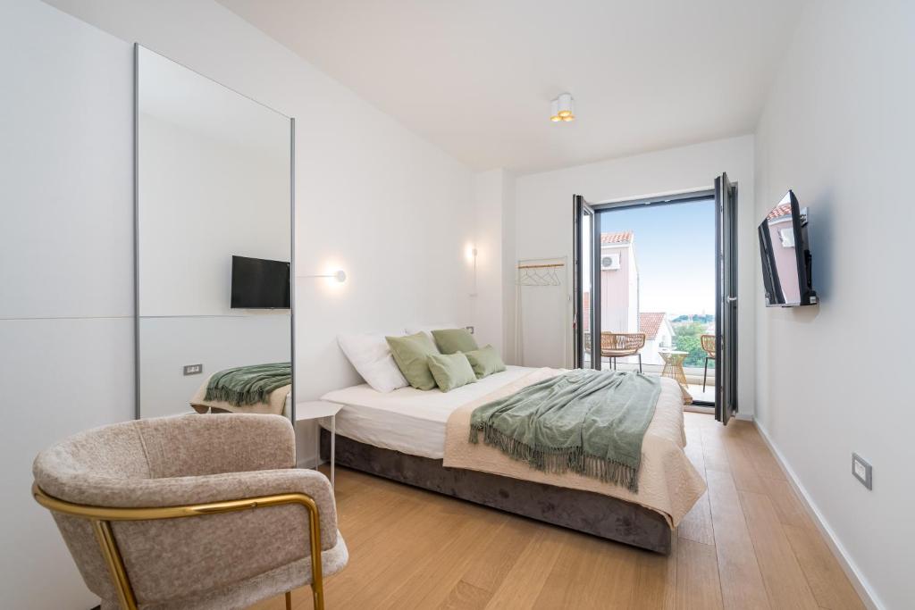 1 dormitorio con 1 cama y 1 silla en Vila Cvita, en Primošten