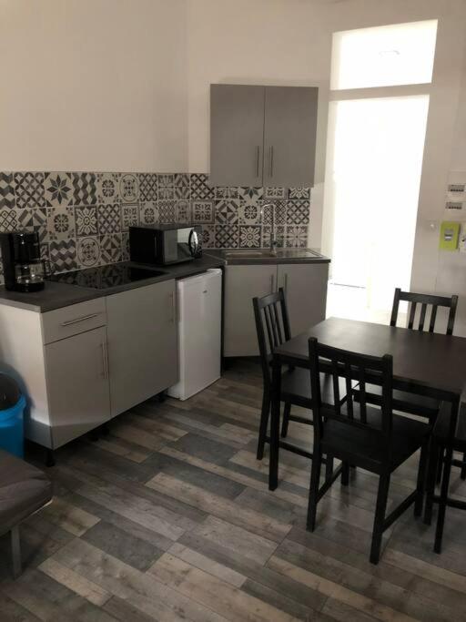 une cuisine avec une table et des chaises et une table et un comptoir dans l'établissement Studio proche de la plage, à Berck-sur-Mer