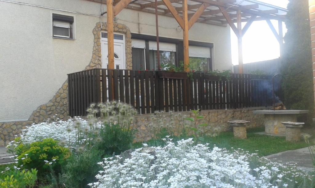 un jardín con flores blancas frente a una casa en Nati és Bea Vendégház, en Hajdúszoboszló