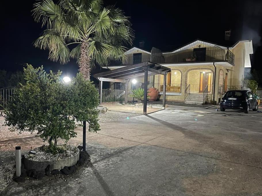 une voiture garée devant une maison avec un palmier dans l'établissement Appartamento-Casalvelino, à Omignano