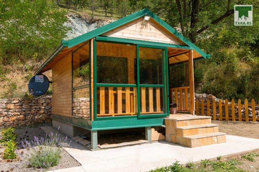 une petite maison avec un toit vert et des escaliers dans l'établissement Air Zaovine, à Bajina Bašta