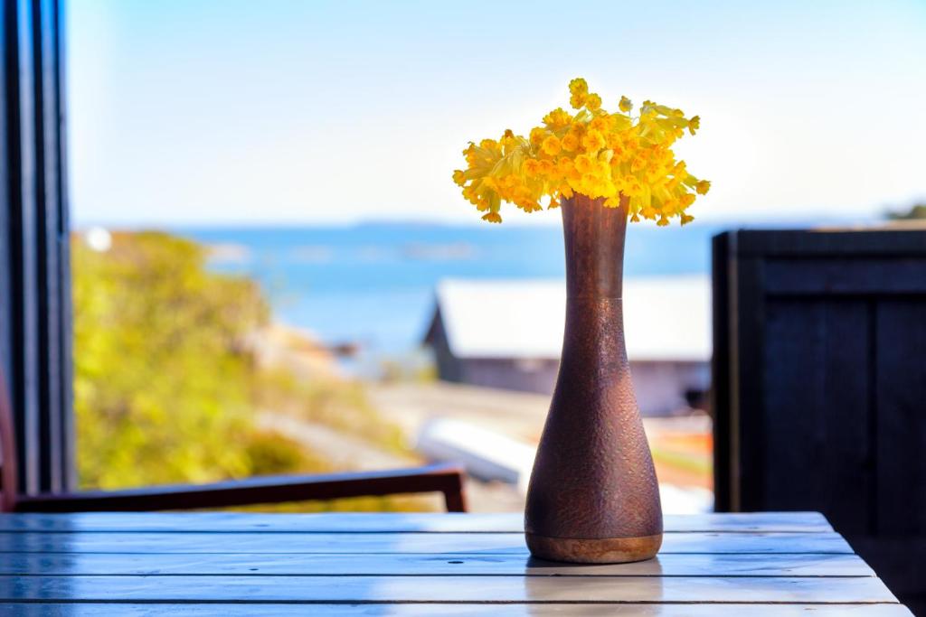 a vase filled with yellow flowers sitting on a table at Isakssons Cottage 1 in Föglö