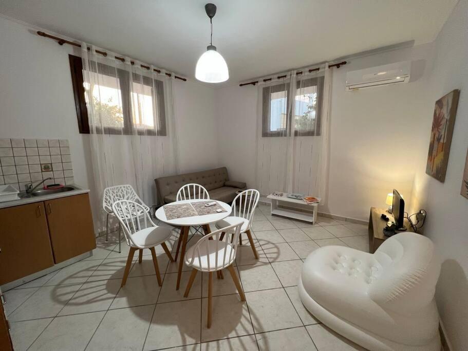 eine Küche und ein Wohnzimmer mit einem Tisch und Stühlen in der Unterkunft Elegant studio by the beach in Ireon in Ireo