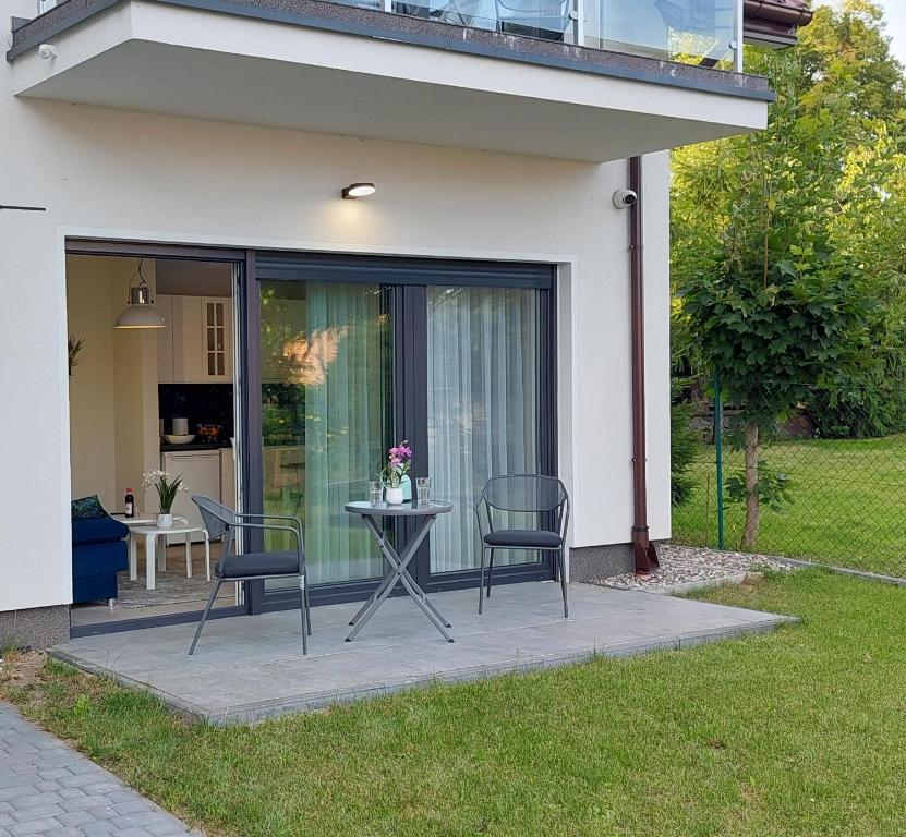 a patio with two chairs and a table in front of a house at Apartment 3 Ferienwohnung Mikolajki in Mikołajki