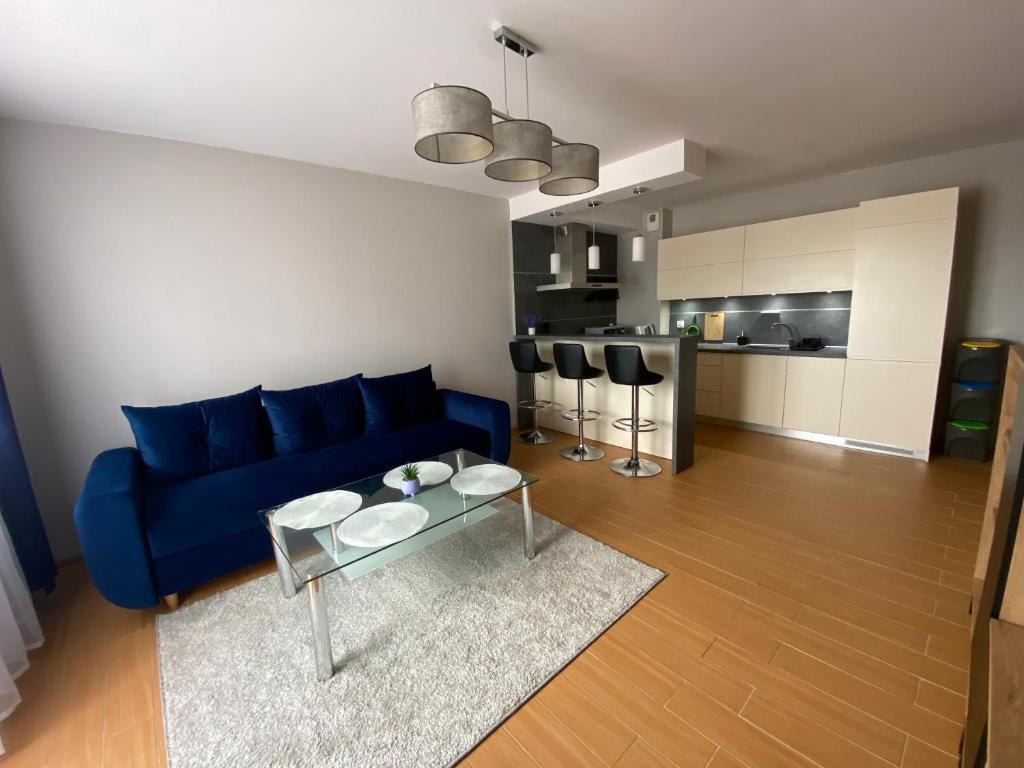 un soggiorno con divano blu e tavolo di Apartament Nova Gniewino a Gniewino