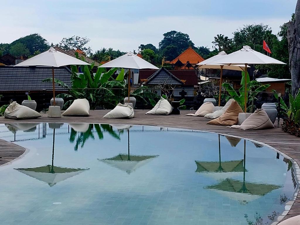 a large swimming pool with pillows and umbrellas at Spaces Bali Unique Boutique Hotel in Munggu