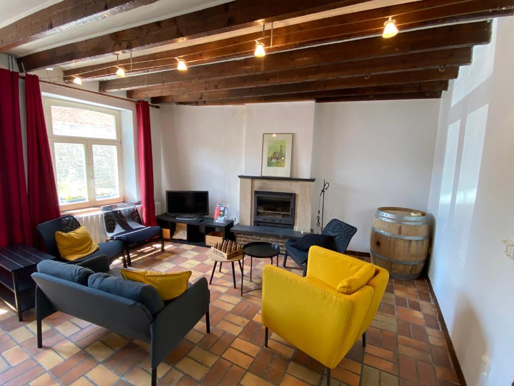 ein Wohnzimmer mit blauen und gelben Möbeln und einem Fass in der Unterkunft La Petite Maison - 8 pers in Walcourt