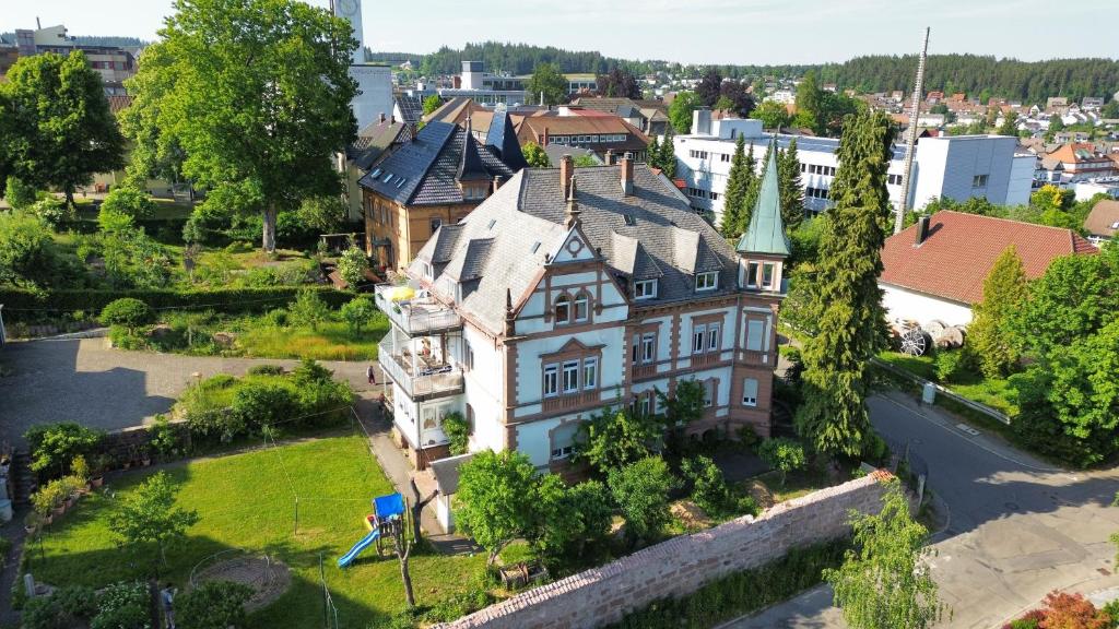 une vue aérienne sur une grande maison dans une ville dans l'établissement Klostereck (Villa C. Haas), à Sankt Georgen im Schwarzwald