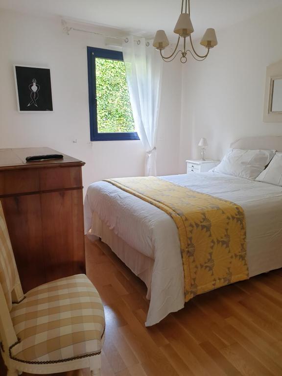 een slaapkamer met een bed, een stoel en een raam bij Le Guépratte in Granville
