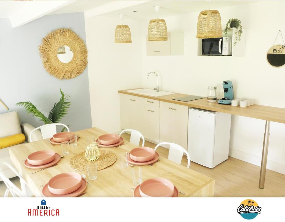 a kitchen and dining room with a table and chairs at Little America - Appart Hôtel 3km Futuroscope in Jaunay-Clan