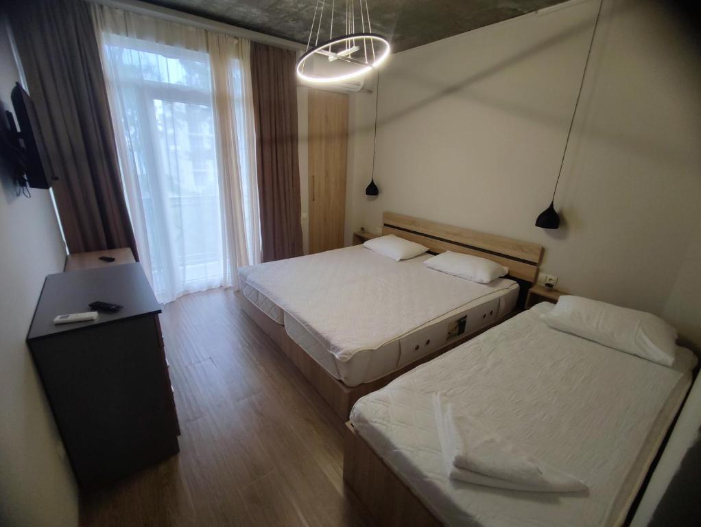 um quarto com 2 camas, uma mesa e uma janela em Home Shekvetili em Shekhvetili