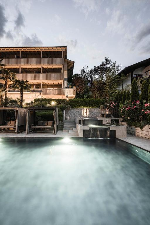 a swimming pool in front of a building at Appartementhaus Residence Hirzer in Tirolo