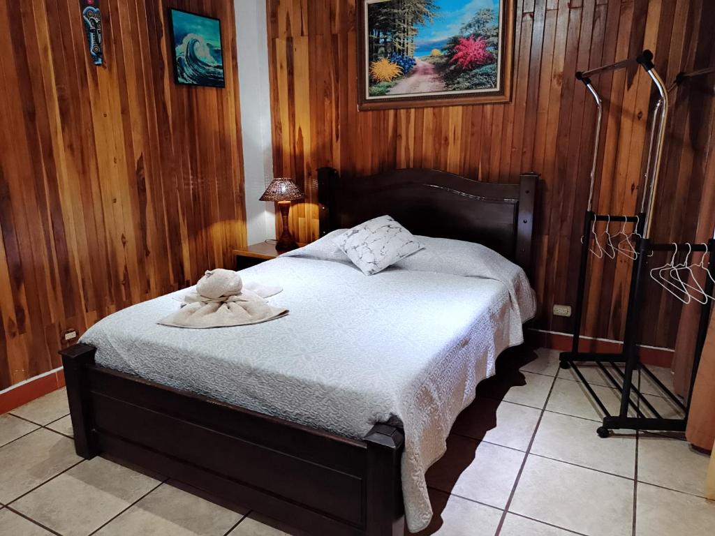 a bedroom with a bed with a hat on it at Natural Pacific Suites, Manuel Antonio-Quepos-Hotel in Manuel Antonio