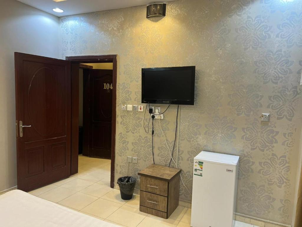 a room with a tv on the wall and a refrigerator at قصر المنار in Jeddah
