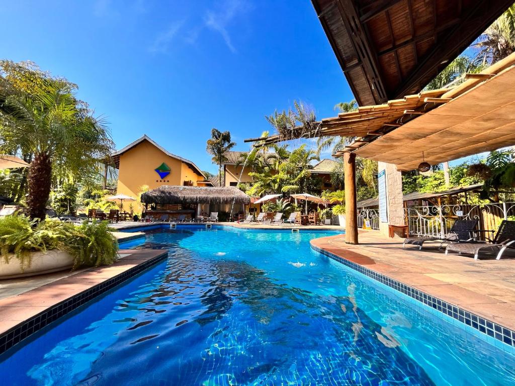 einen Pool in einem Resort mit blauem Wasser in der Unterkunft Suíte 1210 em Flat frente ao mar in Ilhabela