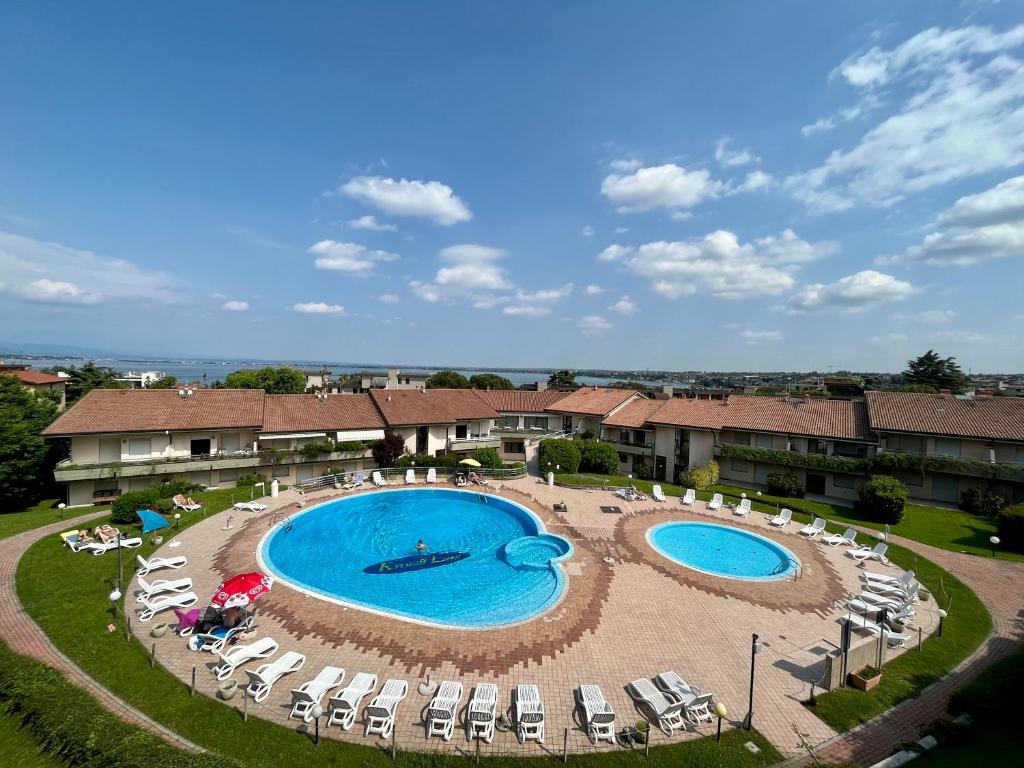 una vista panoramica su due piscine con sedie a sdraio di Kristall Lago Residence a Desenzano del Garda