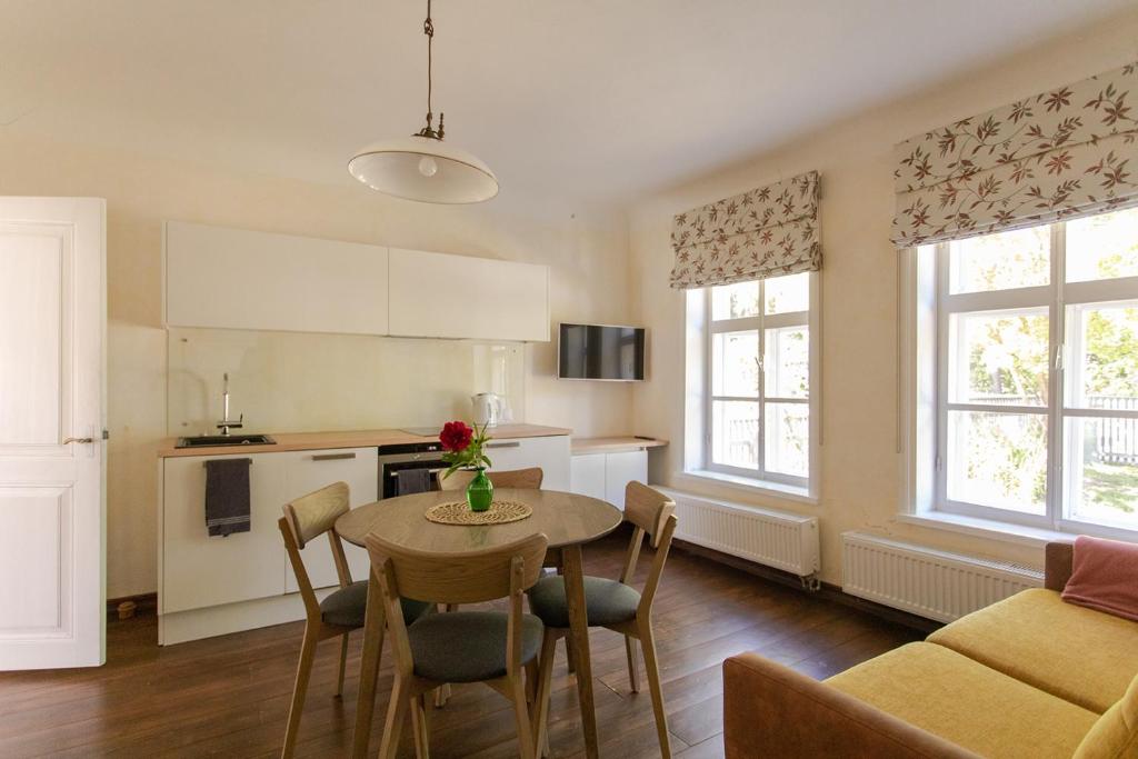 a kitchen and living room with a table and chairs at Allee Apartments in Kuressaare
